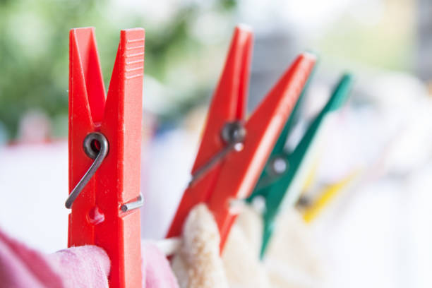 Clothespins holding laundry on the rope. Closeup