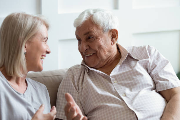 istock Happy mature husband and wife have fun talking on couch 1205448236