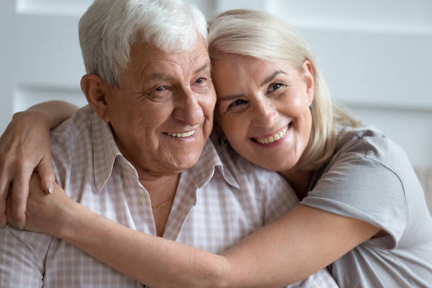 Headshot portrait of loving elderly couple hugging at home Close up headshot portrait of smiling elderly couple hug cuddle showing love and care, family picture of mature husband and wife embrace enjoy tender sweet moment on home weekend together father daughter 80s stock pictures, royalty-free photos & images