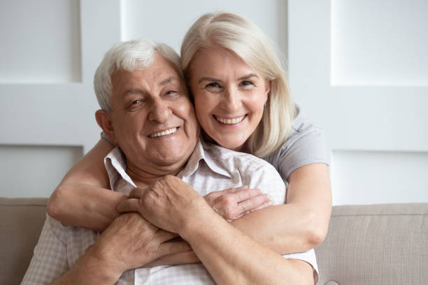 istock Loving senior husband and wife hugging looking at camera 1205448244