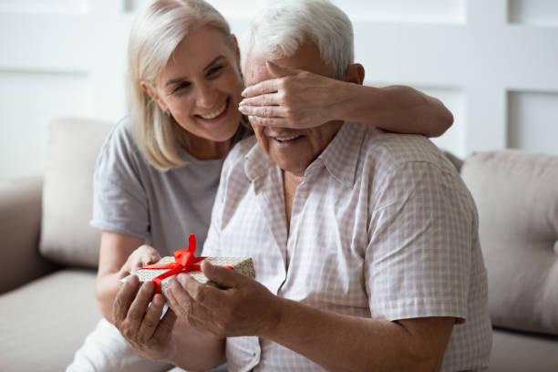 istock Loving mature wife congratulate husband with birthday 1205448248