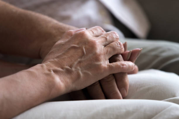 istock Close up of senior couple hold hands showing support 1205448284