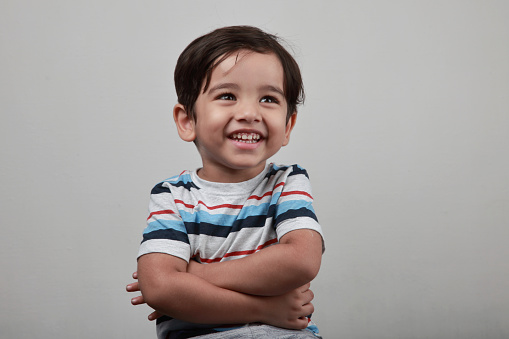 Cute little boy dreaming and thinking on a white background