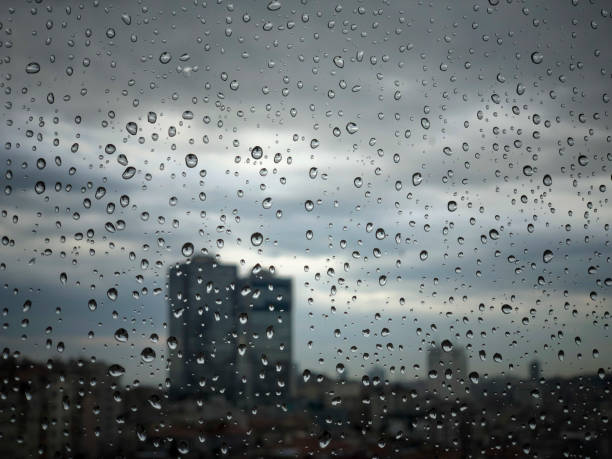 istock rain drops on window pane against city view 1205453868