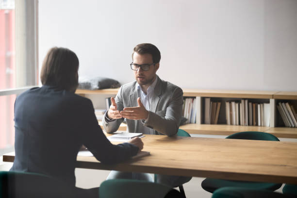 due uomini d'affari che hanno una conversazione, seduti a tavola in sala riunioni - ceo serious board room manager foto e immagini stock