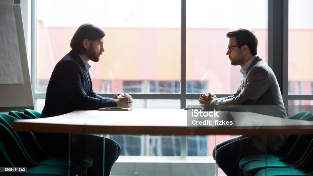 Zwei Geschäftsleute, die am Tisch sitzen, Konfrontation und Verhandlungen - Lizenzfrei Gespräch Stock-Foto