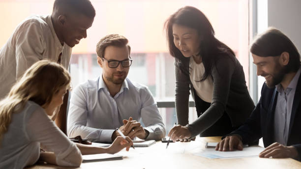 istock Employees with team leader working on new project at meeting 1205454389