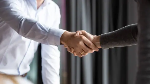 Close up partners shaking hands, making agreement, legal deal after successful negotiation, acquaintance and greeting concept, business people handshake, collaboration and partnership symbol