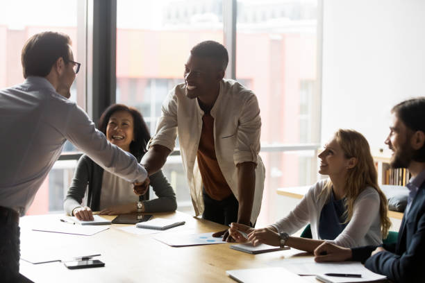 istock Diverse business partners shaking hands at meeting, making agreement 1205454405