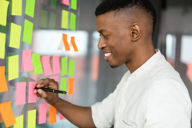 istock Smiling African American businessman writing on sticky papers 1205454416