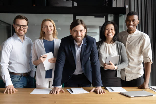 istock Smiling diverse business people with team leader looking at camera 1205454421