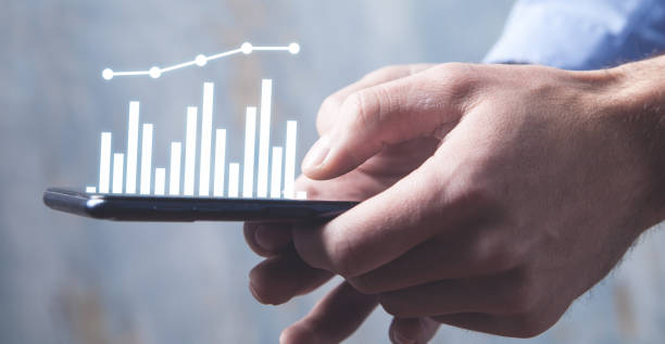 istock Man holding smartphone with a business graph. Business concept 1205455921