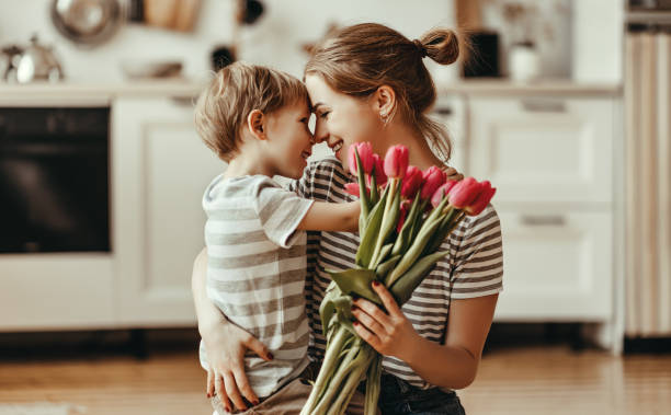 buona festa della mamma! figlio dà fiori per la madre in vacanza - mother enjoyment built structure human head foto e immagini stock