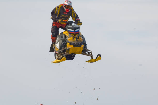 saut en hauteur de sportif sur la motoneige - snow jumping snowmobiling sled photos et images de collection
