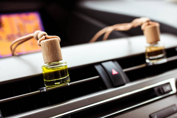 botellas de ambientador de perfume de aire de coche dentro del coche en el panel del coche. líquido aromático en la botella pequeña. - car freshner fotografías e imágenes de stock