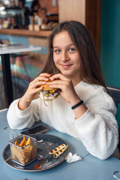 Teenage girl eating hamburger