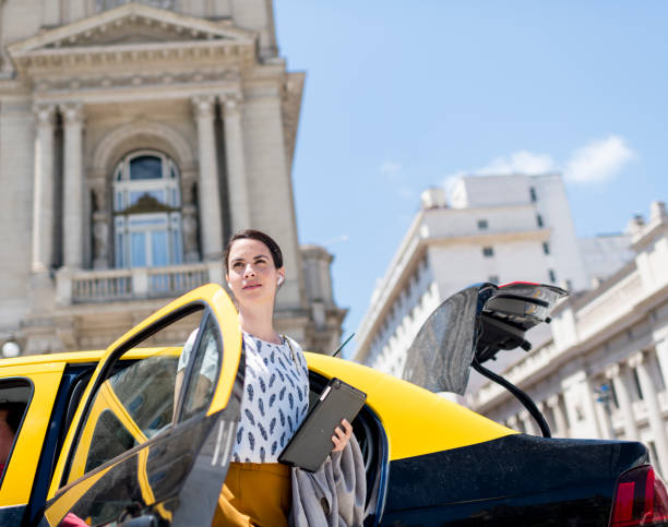 una joven que viaja por negocios se sale de un taxi - taxi buenos aires people city fotografías e imágenes de stock