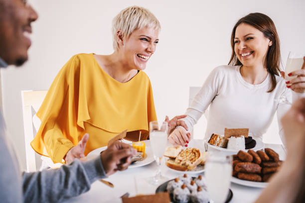 istock Two best female friends sitting at dinning table, laughing and chatting. 1205464596