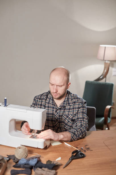 istock Tailor makes bow ties of woolen fabric. Work with sewing machine in a textile studio. 1205464719