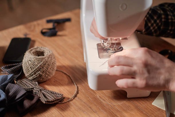 istock Tailor makes bow ties of woolen fabric. Work with sewing machine in a textile studio. 1205464782