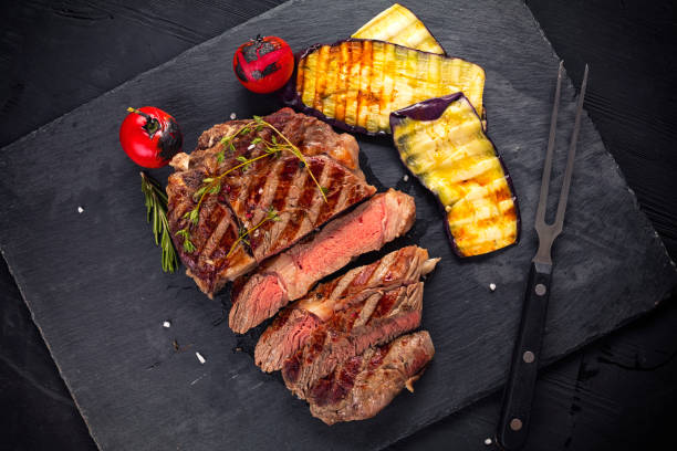 istock medium rare beef steak on ceramic board with herbs spices and salt. 1205468037