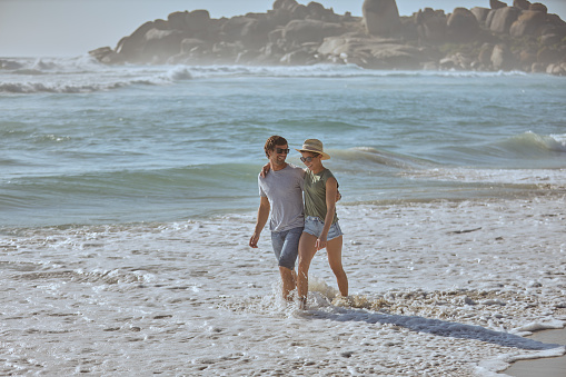 Shot of a happy young couple going for a romantic walk along the beach
