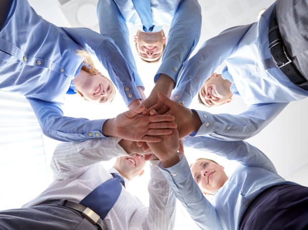 istock group of smiling businesspeople stacking hands 1205468933