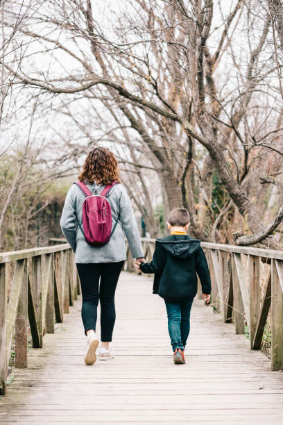 istock Mother and son crossing a bridge together 1205469430