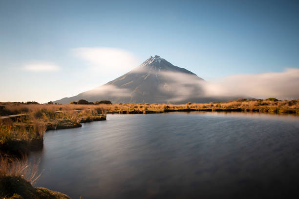 istock Majestic Mount Taranaki with fast moving clouds 1205470101
