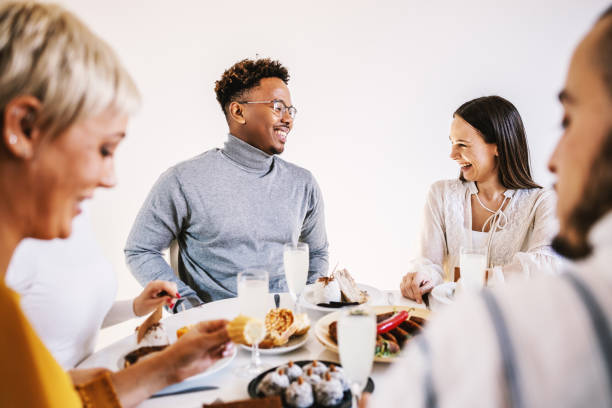 istock Top view of five multicultural friends sitting at dinning table and having healthy lunch. 1205470454