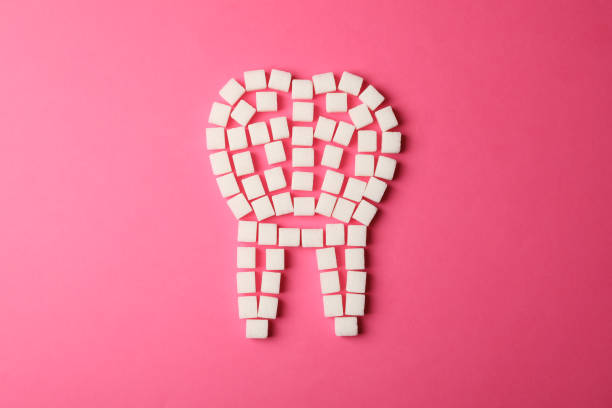 istock Tooth made of sugar cubes on pink background, top view 1205472303