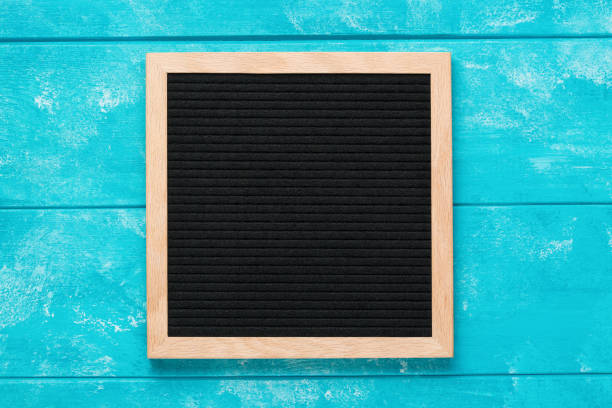 istock Empty black letterboard on blue wooden table. Design mockup 1205473159