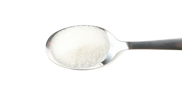 Spoon with sugar isolated on white background, close up