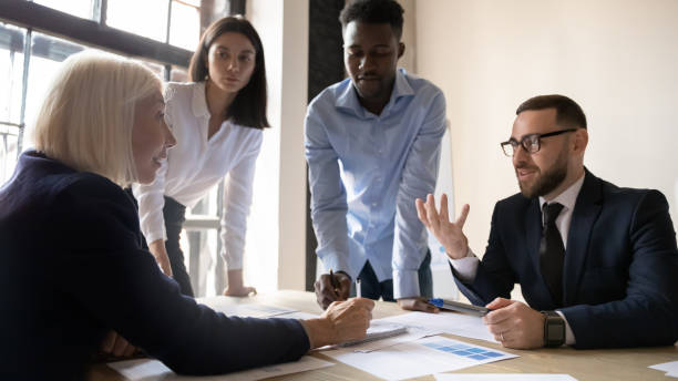 istock Young and older leaders consider business ideas collaborating at meeting 1205475161