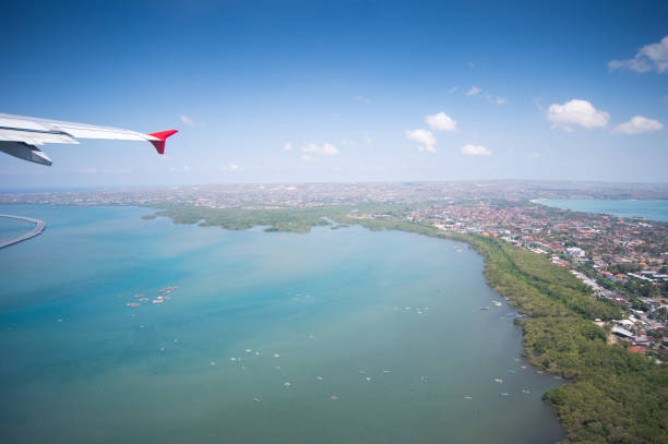 istock Tropical island coastline view from the plane island sneak peaking through the clouds seen from a plane's window Bali ,Indonesia 1205476521
