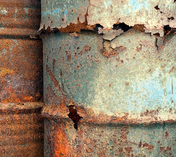 A close view of completely rusted out oil barrels