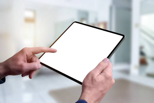 istock Tablet mockup in man hands. Living room interior in background 1205477720