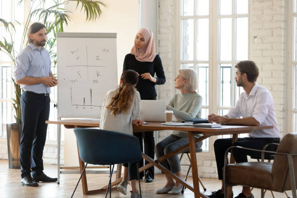 istock Multicultural speakers make presentation for colleagues at meeting 1205480354