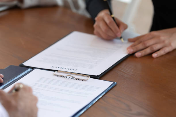 istock Diverse businesspeople sign document closing deal at briefing 1205480402