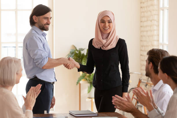 istock Smiling multiethnic employees handshake greeting with promotion 1205480445