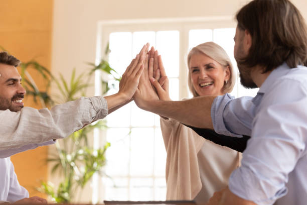 istock Happy diverse colleagues join hands celebrating work achievements 1205480447