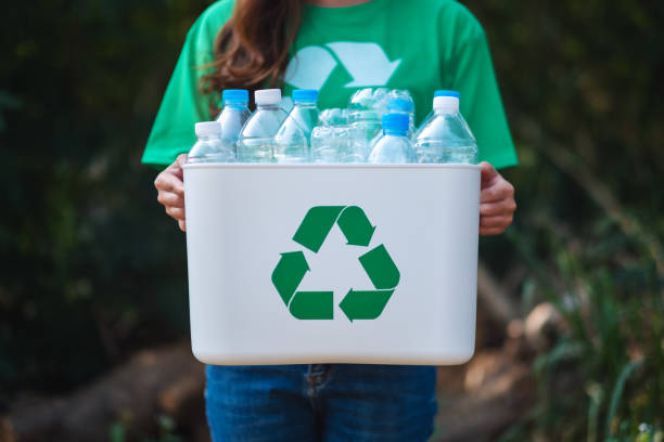 istock A woman collecting garbage and holding a recycle bin with plastic bottles 1205480593