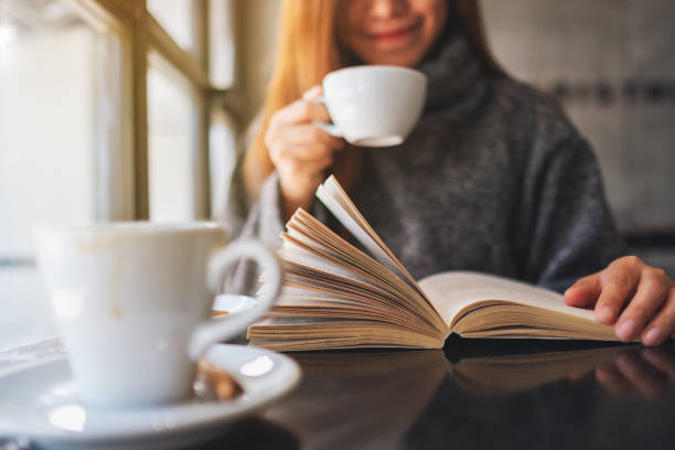 istock a beautiful woman reading a book while drinking coffee in the morning 1205480660