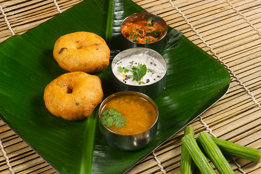 Medu wada with sambar and chutney, South Indian breakfast or snack dish on banana leaf
