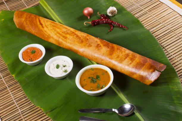 Masala dosa on banana leaf with both sambar and coconut chutney. South Indian Vegetarian Snack Masala dosa on banana leaf with both sambar and coconut chutney. South Indian Vegetarian Snack Dosa stock pictures, royalty-free photos & images