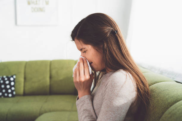 istock Woman blowing her nose on the sofa 1205482711
