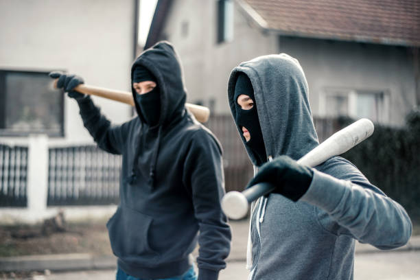 Young men holding a baseball bat symbolizing crime stock photo