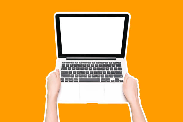 istock Laptop isolated on an orange background. Computer with a white blank screen in female hands. Colorful layout design. 1205485515