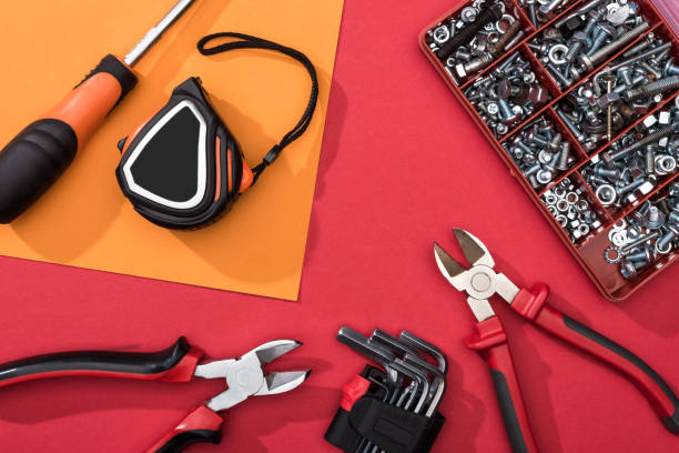 istock Top view of tool box with pliers and hex keys on orange and red surface 1205487068