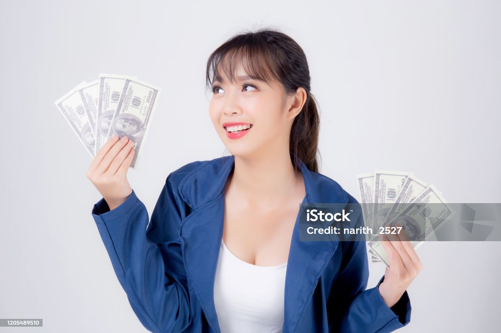 Beautiful portrait young business asian woman holding money isolated on white background, businesswoman showing banknotes with excited, happy girl income with profit finance and success concept. Lottery Stock Photo